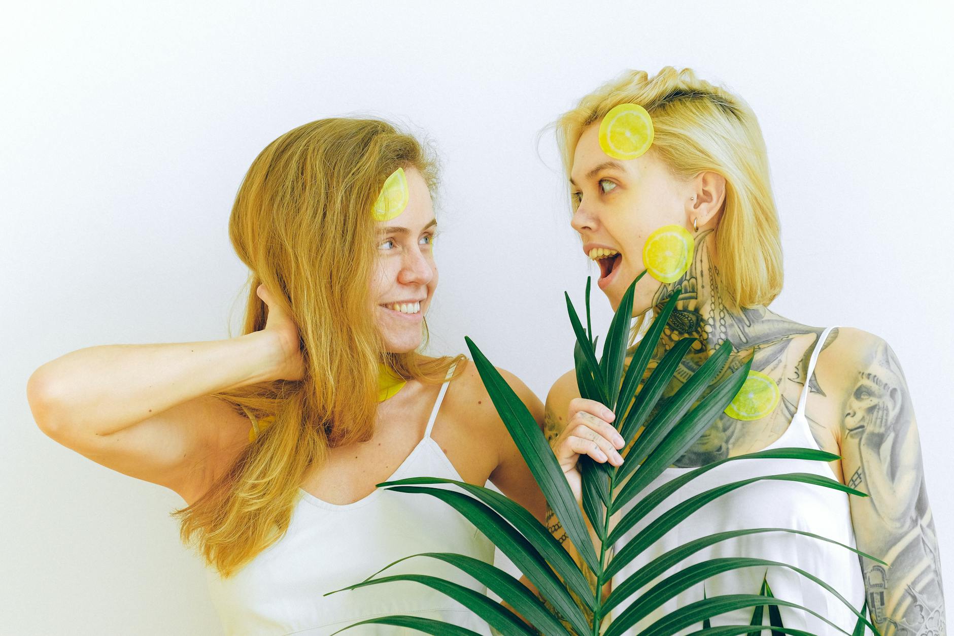 Two women laughing together while enjoying lemon slices, embodying joy and freedom in pleasure exploration