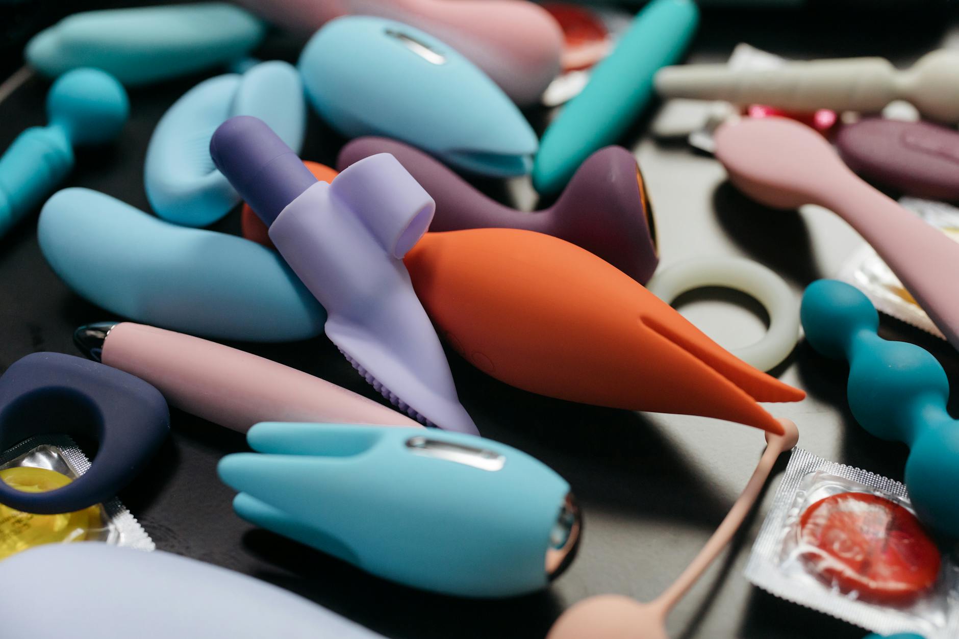 Woman holding a pink vibrator against a background of art books, symbolizing personal discovery and returning to pleasure