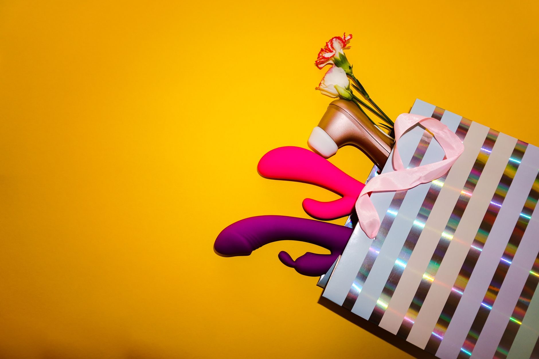 A hand holding a vibrant clitoral vibrator with a minimalistic backdrop, showcasing modern design and tactile comfort.